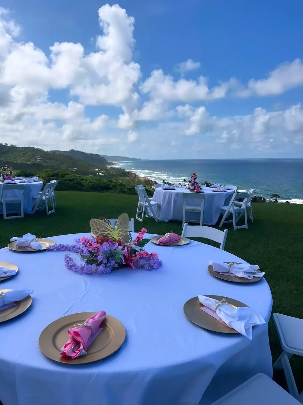 Outdoor celebration tables set on the lawn with the Atlantic coastline behind